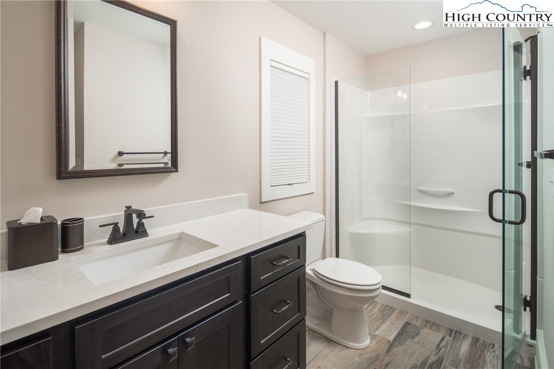 103 Dugger Rdg Trail Boone, NC 28607 - Photo 27 of 49 a bathroom with a sink a toilet a mirror and shower