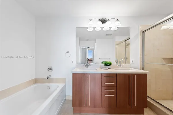 a bathroom with a double vanity sink mirror and shower