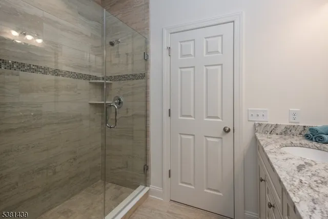 a bathroom with a granite countertop sink a shower and a mirror