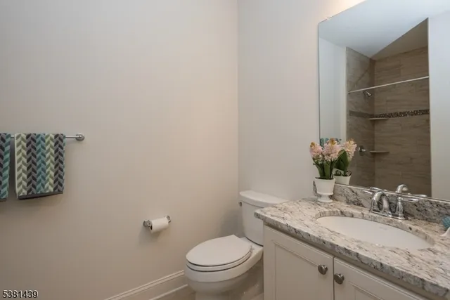 a bathroom with a granite countertop toilet sink and mirror