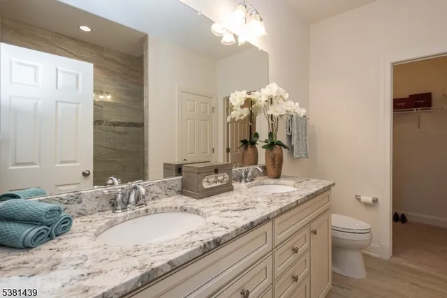 a bathroom with a granite countertop double vanity sink and a mirror