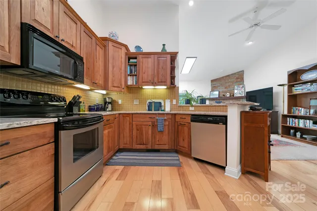a kitchen with stainless steel appliances granite countertop a stove a sink dishwasher and a microwave oven with cabinets