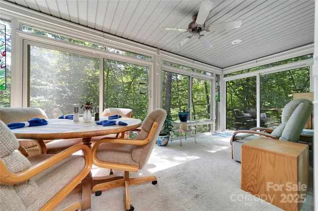 a living room with furniture and floor to ceiling windows