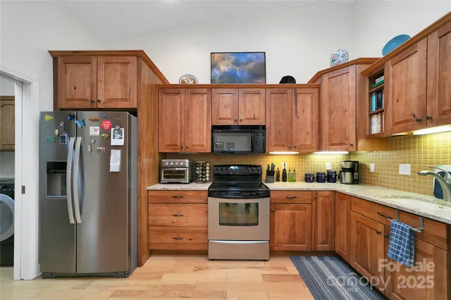 a kitchen with stainless steel appliances granite countertop a refrigerator and a stove top oven
