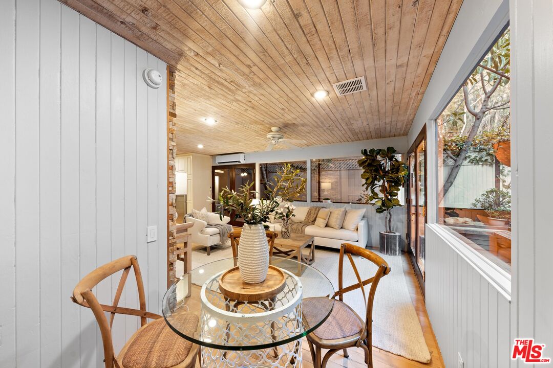 11612 Chenault Street, Unit 4 Los Angeles, CA 90049 - Photo 11 of 28 a dining room with furniture and a floor to ceiling window