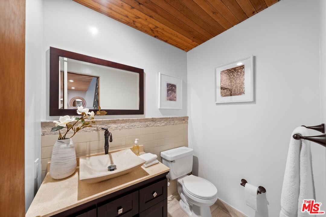 11612 Chenault Street, Unit 4 Los Angeles, CA 90049 - Photo 12 of 28 a bathroom with a sink a toilet and mirror
