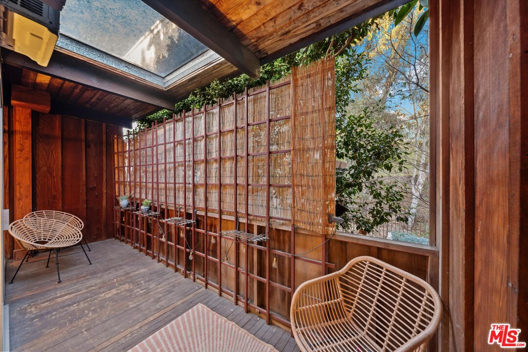 11612 Chenault Street, Unit 4 Los Angeles, CA 90049 - Photo 17 of 28 a view of a balcony with a potted plant and wooden floor