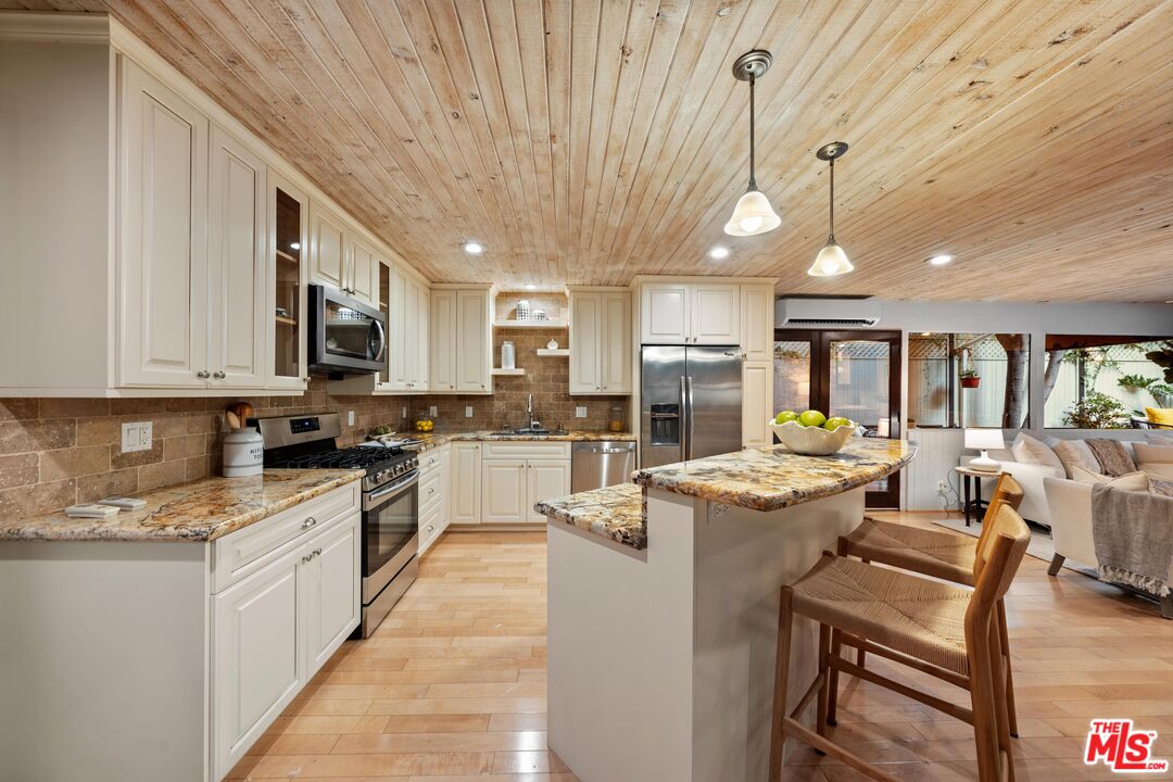 11612 Chenault Street, Unit 4 Los Angeles, CA 90049 - Photo 3 of 28 a open kitchen with stainless steel appliances granite countertop a stove and cabinets