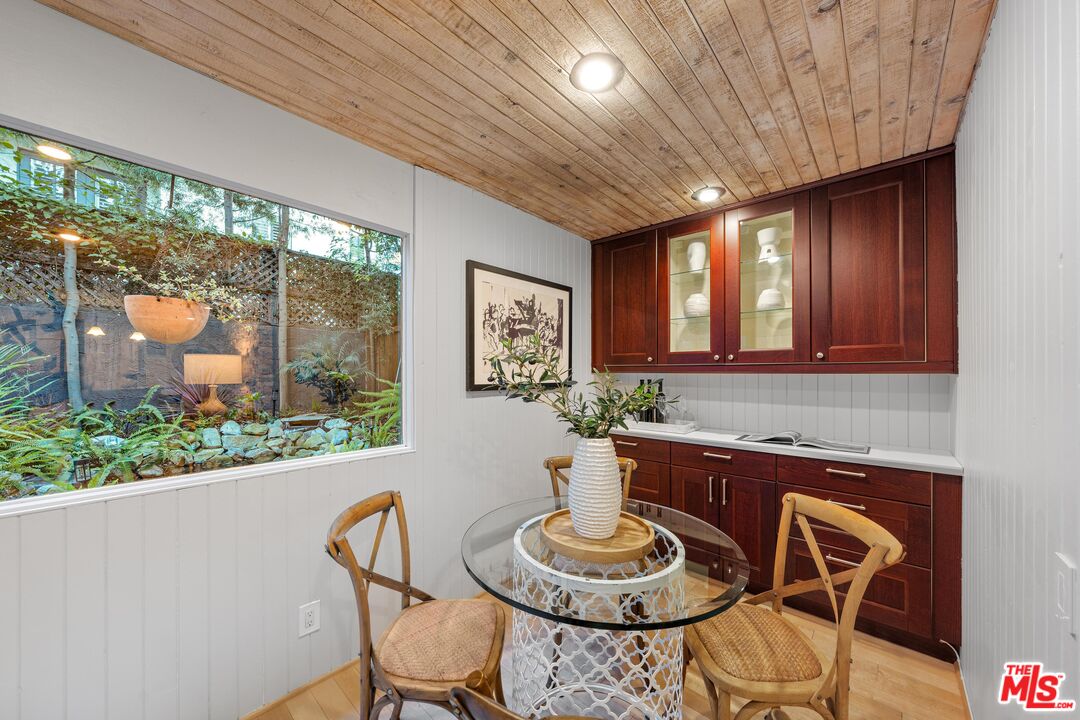 11612 Chenault Street, Unit 4 Los Angeles, CA 90049 - Photo 10 of 28 a dining room with furniture a large window and wooden floor