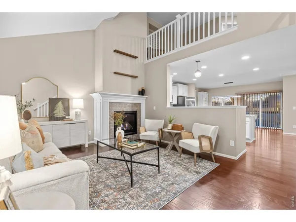a kitchen with stainless steel appliances granite countertop a sink a stove a refrigerator and white cabinets