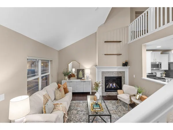 a kitchen with stainless steel appliances granite countertop a stove top oven a sink dishwasher and white cabinets with wooden floor