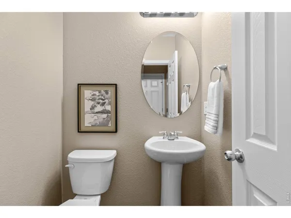 a bathroom with a sink a toilet a mirror and shower