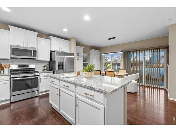 a kitchen with granite countertop a sink a counter top space stainless steel appliances and cabinets