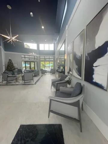 a living room with kitchen island granite countertop furniture a large window and a flat screen tv