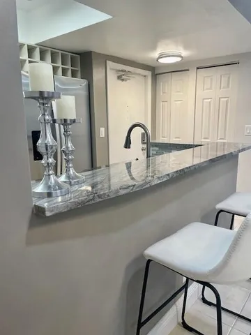 a view of kitchen with stainless steel appliances granite countertop refrigerator sink and stove