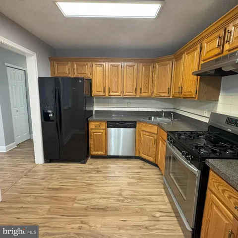 a kitchen with stainless steel appliances granite countertop a stove a refrigerator and a sink