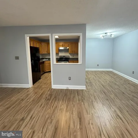 a view of a room with wooden floor and a ceiling fan