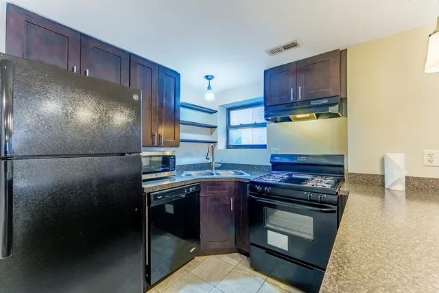 a kitchen with stainless steel appliances granite countertop a stove a refrigerator and a sink