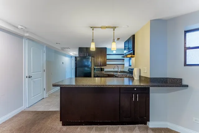 a kitchen with kitchen island a counter top space cabinets and stainless steel appliances
