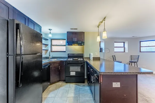 a kitchen with stainless steel appliances granite countertop a refrigerator a stove a sink and a refrigerator