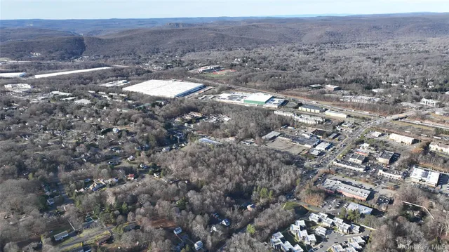 an aerial view of house with yard and mountain view in back