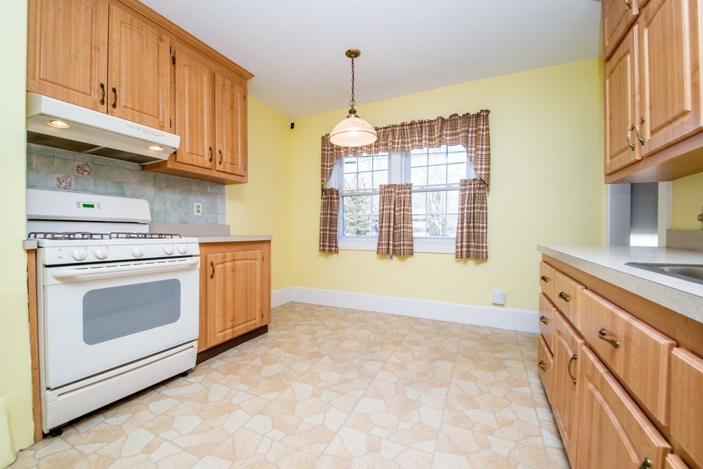 236 Russells Mills Road Dartmouth, MA 02748 - Photo 11 of 30 a kitchen with granite countertop a stove a sink dishwasher and a microwave oven with cabinets