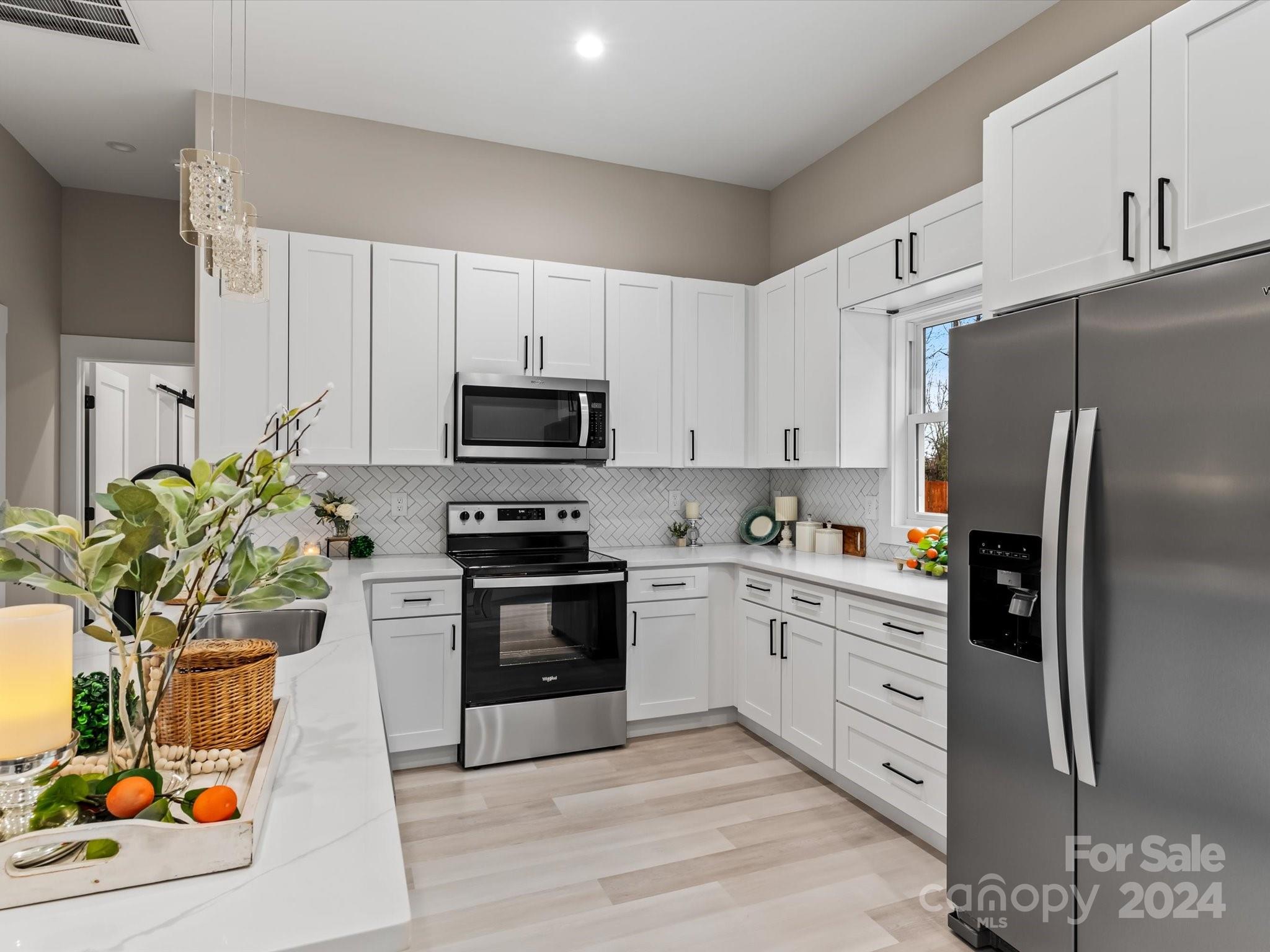 a kitchen with stainless steel appliances granite countertop a refrigerator sink and stove