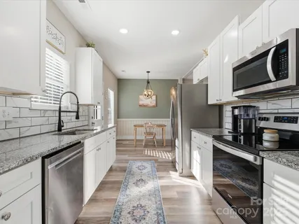 a kitchen with stainless steel appliances granite countertop a sink and a stove