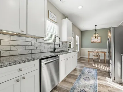 a kitchen with stainless steel appliances granite countertop a sink stove and cabinets