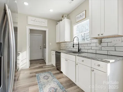 a kitchen with granite countertop a sink and a refrigerator