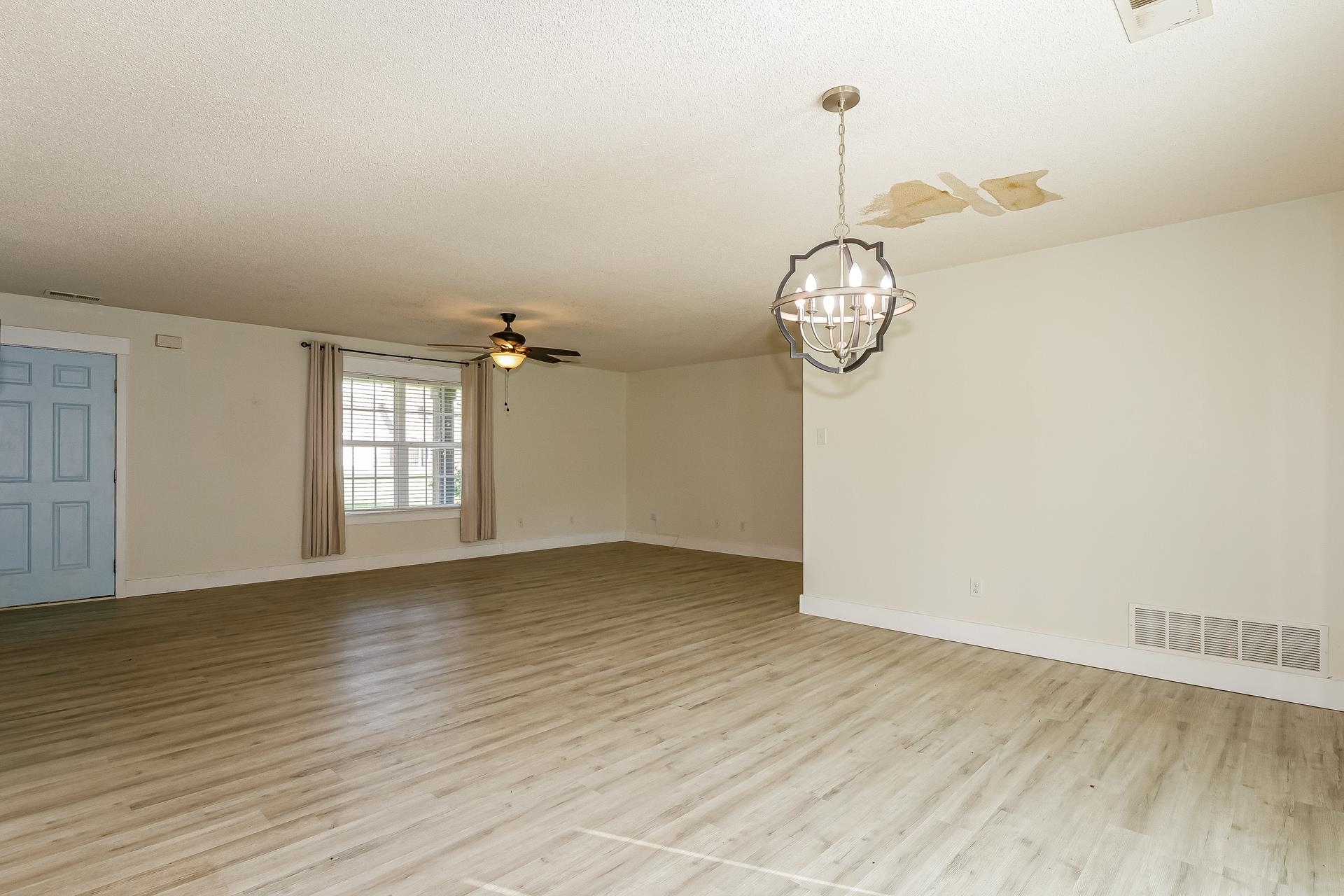 188 David Reed Drive Munford, TN 38058 - Photo 6 of 20 Spacious room with wood-finish flooring, a contemporary ceiling fixture, a ceiling fan, and a light blue entry door