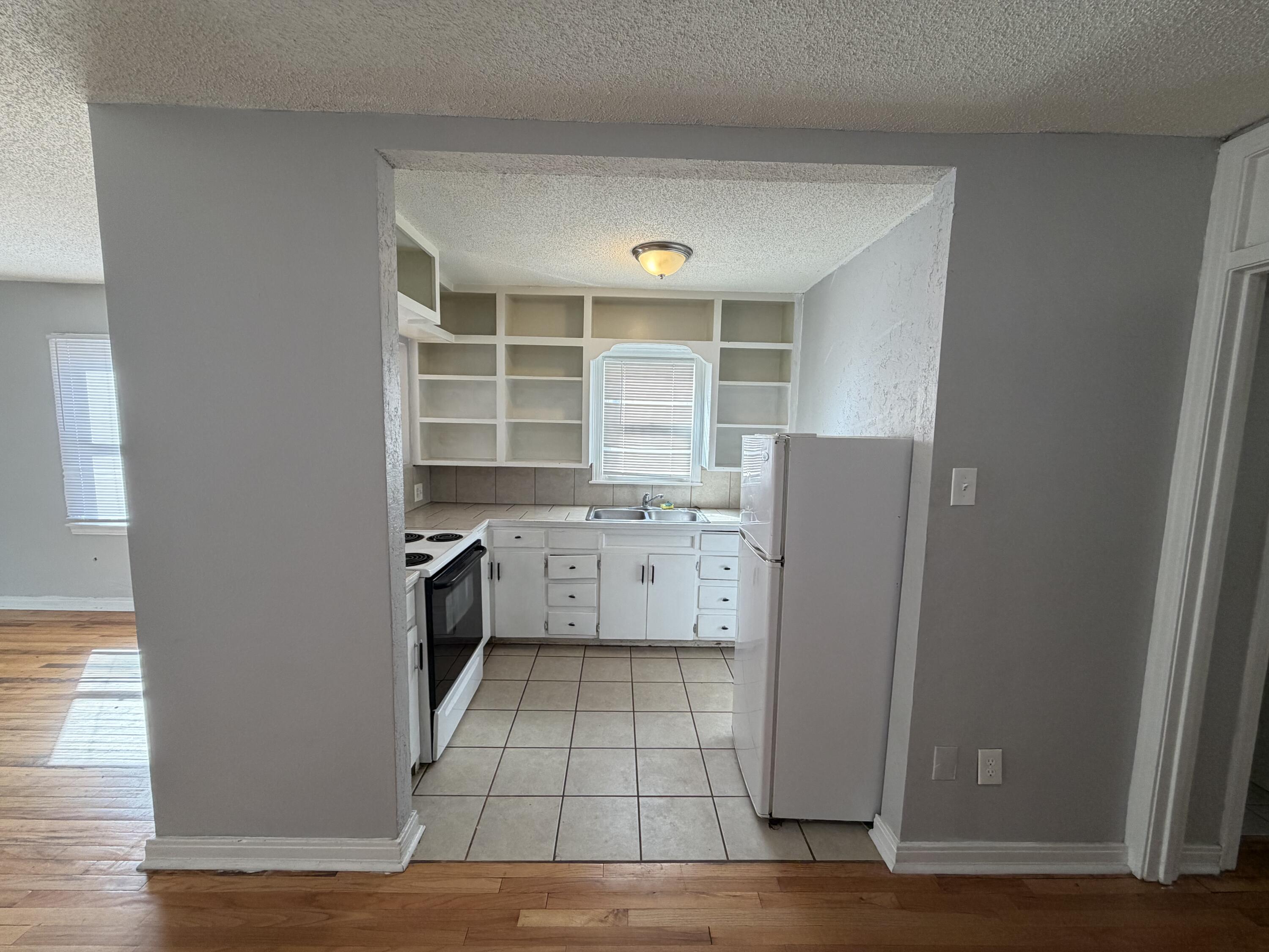 1708 14th Street, Unit 3 Lubbock, TX 79401 - Photo 2 of 5 a kitchen with a refrigerator and a stove