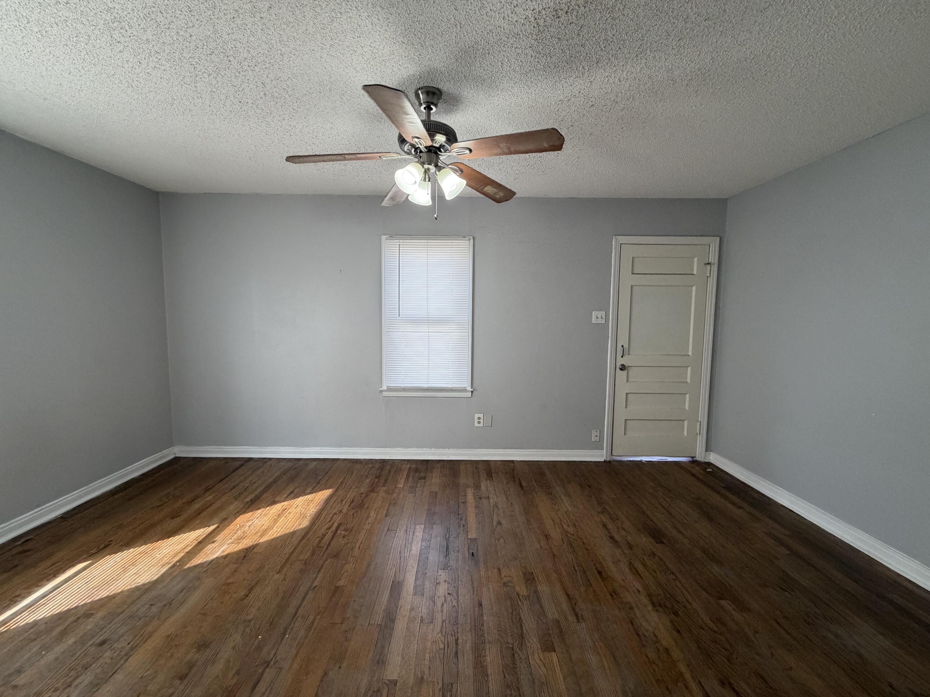 1708 14th Street, Unit 3 Lubbock, TX 79401 - Photo 3 of 5 wooden floor in an empty room with a window