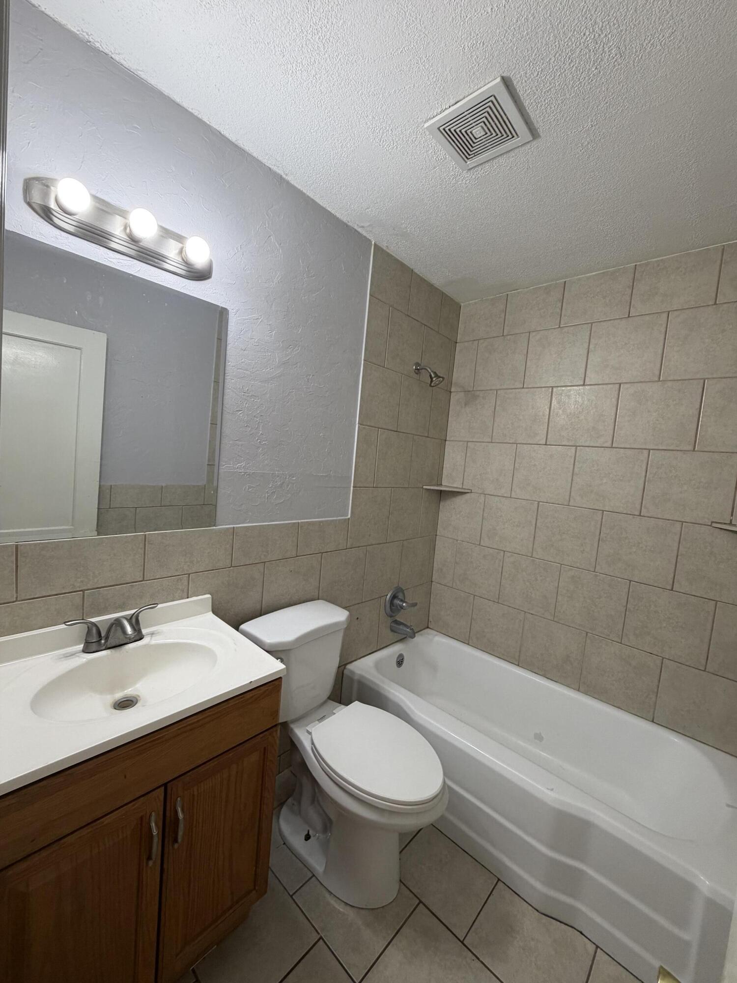 1708 14th Street, Unit 3 Lubbock, TX 79401 - Photo 4 of 5 a bathroom with a toilet a sink a mirror and bathtub