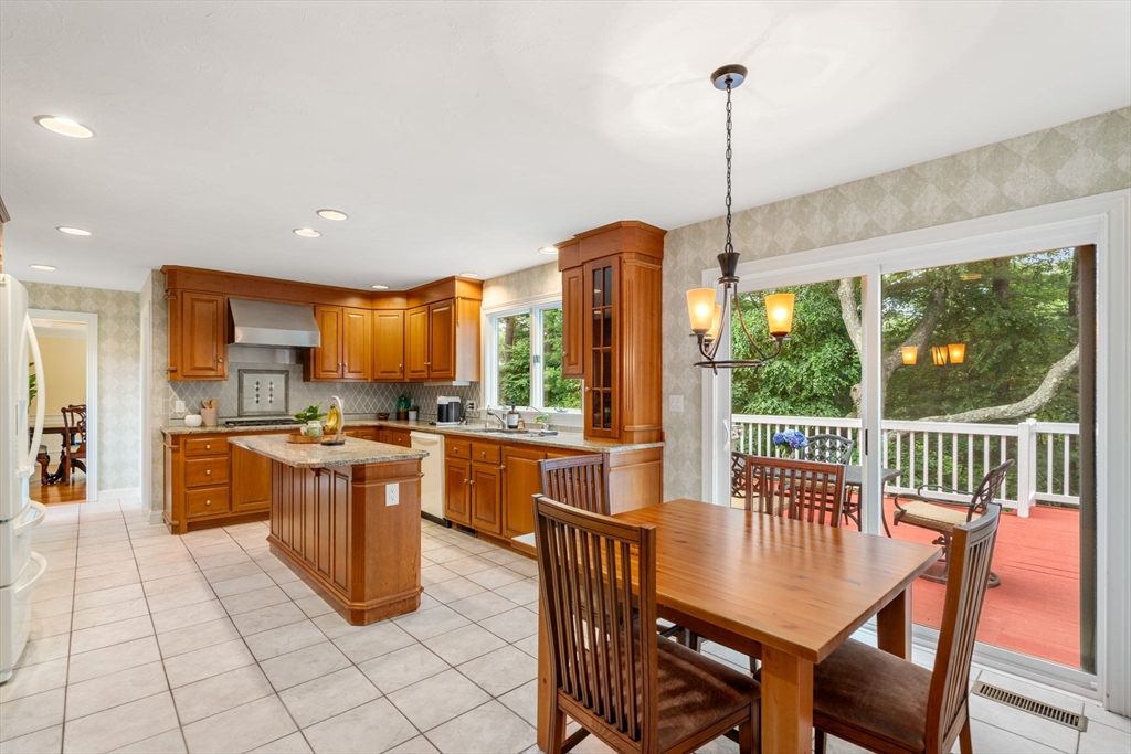 8 Stoneybrook Circle Andover, MA 01810 - Photo 12 of 37 a kitchen with stainless steel appliances granite countertop a stove a refrigerator a kitchen island a table and chairs in it
