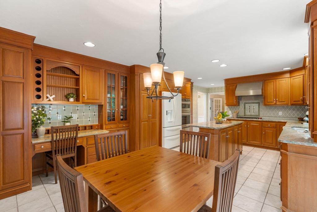 8 Stoneybrook Circle Andover, MA 01810 - Photo 13 of 37 a kitchen with stainless steel appliances kitchen island granite countertop a refrigerator a stove top oven a sink with island and chairs