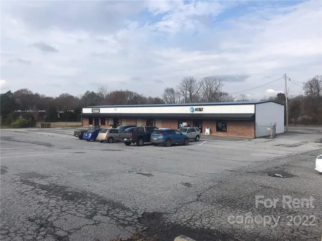a view of a big house with a big yard and large trees