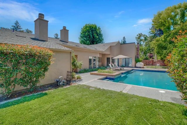 an aerial view of a house with swimming pool garden and patio