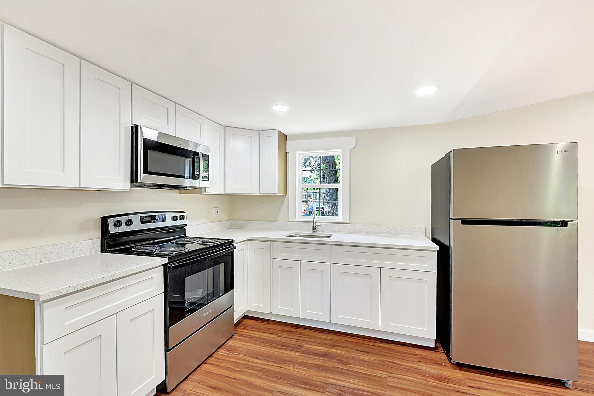 215 Freysville Road York, PA 17406 - Photo 6 of 19 a kitchen with a sink a refrigerator a microwave and cabinets