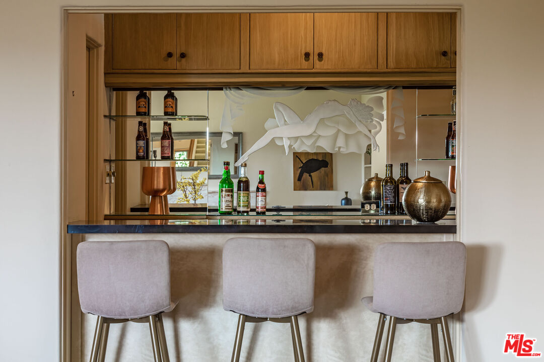 540 Adelaide Drive Santa Monica, CA 90402 - Photo 5 of 45 a kitchen with stainless steel appliances granite countertop a table chairs in it and wooden floors