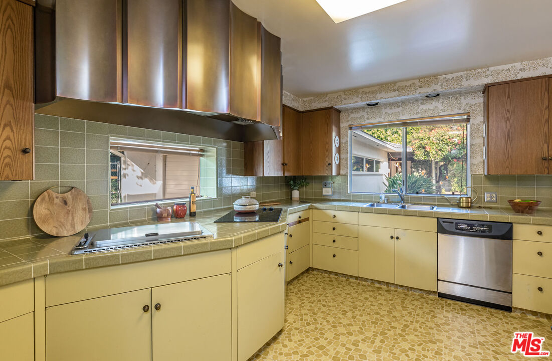 540 Adelaide Drive Santa Monica, CA 90402 - Photo 9 of 45 a kitchen with kitchen island granite countertop a sink cabinets and stainless steel appliances