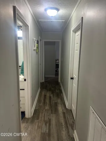 a view of a hallway with wooden floor