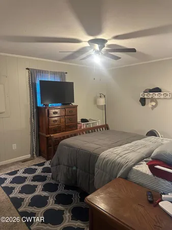 a bedroom with a bed and a television