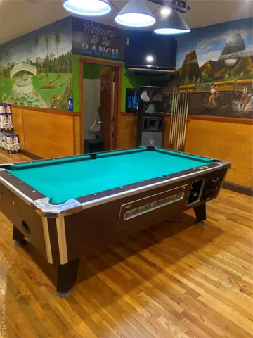 a room with pool table and windows
