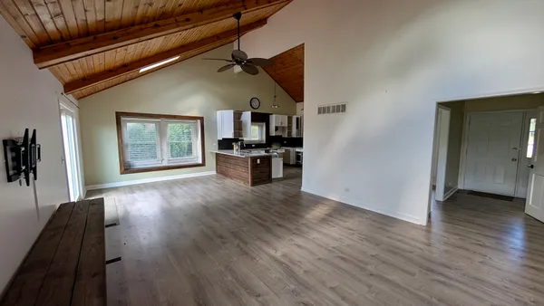 a view of a living room hardwood floor and a kitchen
