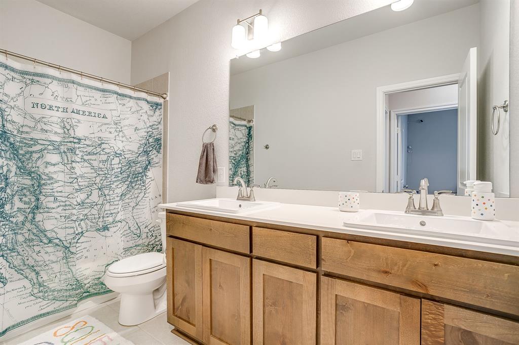 10371 Trail Ridge Drive Fort Worth, TX 76126 - Photo 31 of 35 a bathroom with a granite countertop sink toilet a large mirror and shower