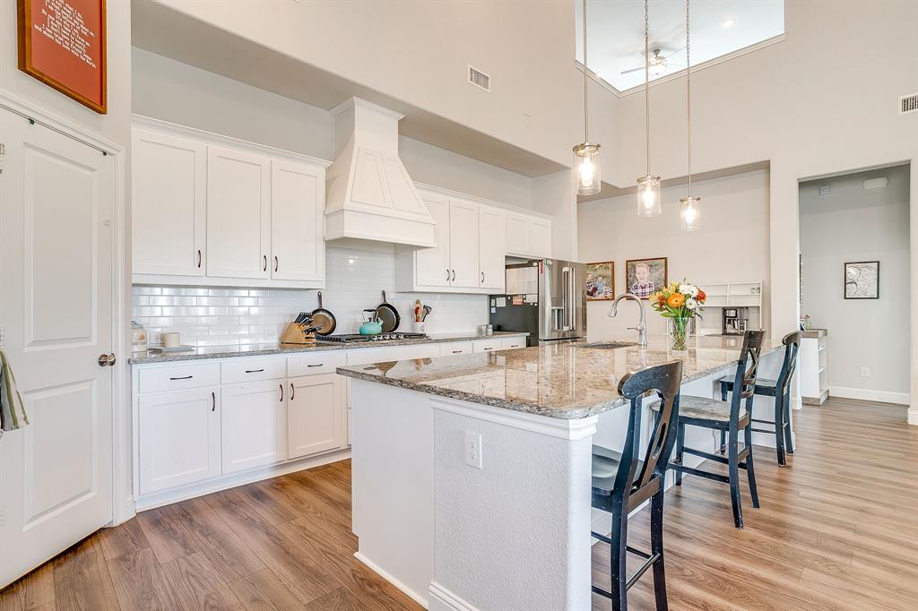 10371 Trail Ridge Drive Fort Worth, TX 76126 - Photo 9 of 35 a kitchen with stainless steel appliances kitchen island granite countertop a dining table chairs and white cabinets