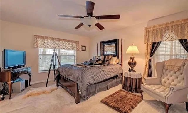 a spacious bedroom with a bed a couch and a window