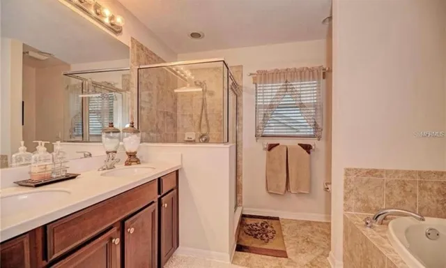 a bathroom with a granite countertop sink a mirror and shower