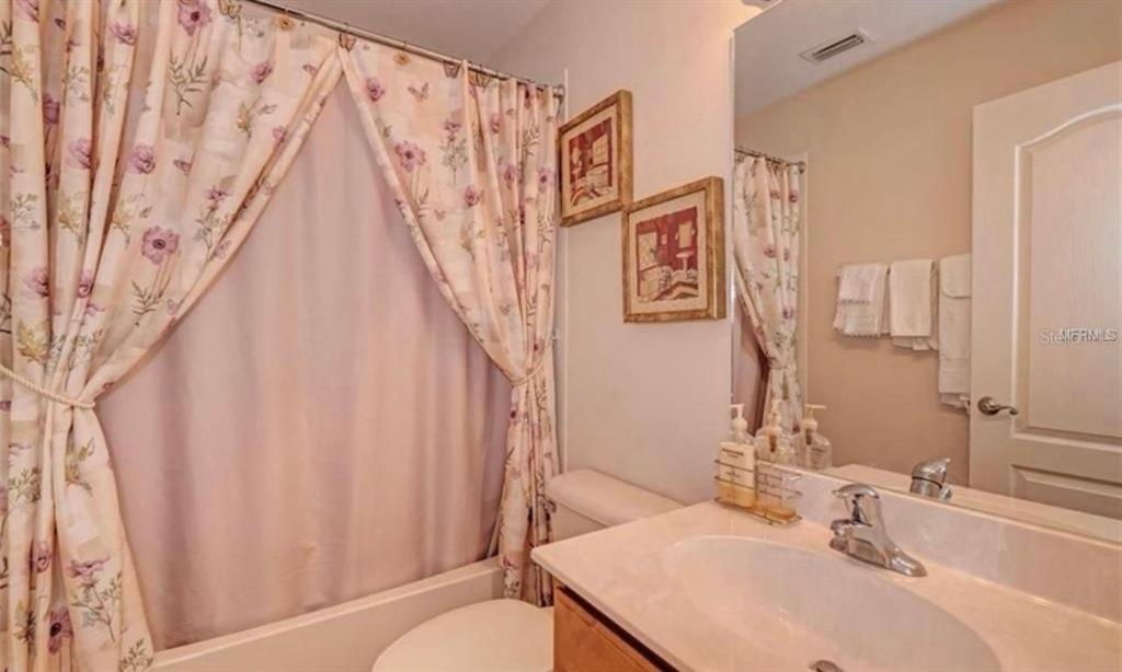 15108 Skip Jack Loop Lakewood Ranch, FL 34202 - Photo 19 of 23 a bathroom with a sink and a mirror